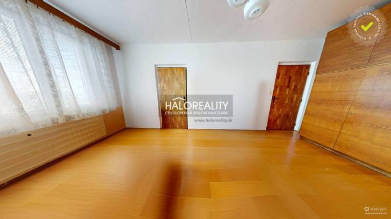 Pokoj v 3-pokojovém bytě s podlahou s dřevěným dekorem, velkým oknem a vestavěnou skříní.