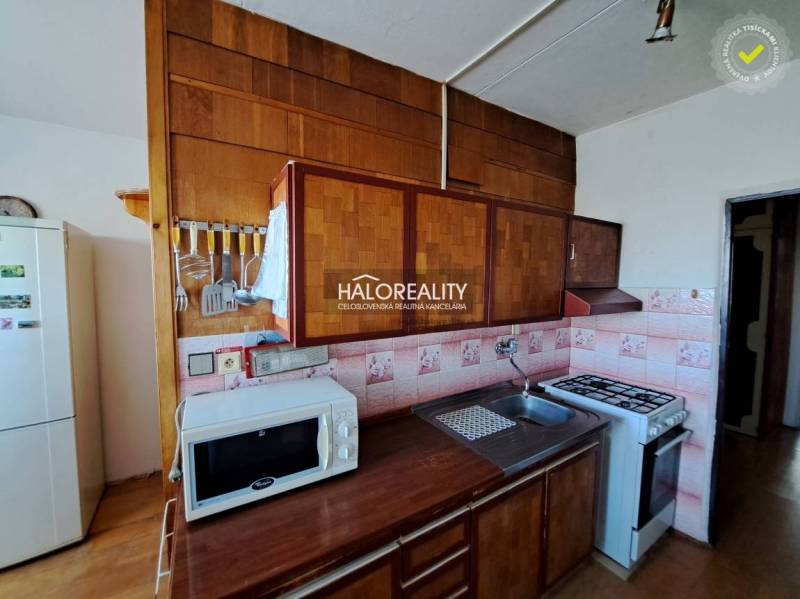 Obývací pokoj v 3pokojovém bytě s pohovkami, podlahou s dřevěným dekorem a velkými okny.