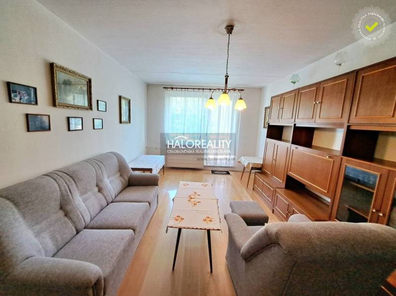 Obývací pokoj se světlem, podlahou s dřevěným dekorem a nábytkem ve 3-pokojovém bytě.