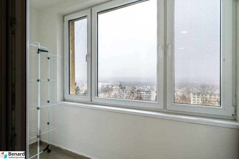 Balkon s výhledem v 2pokojovém bytě, sušák na prádlo, město v mlze.