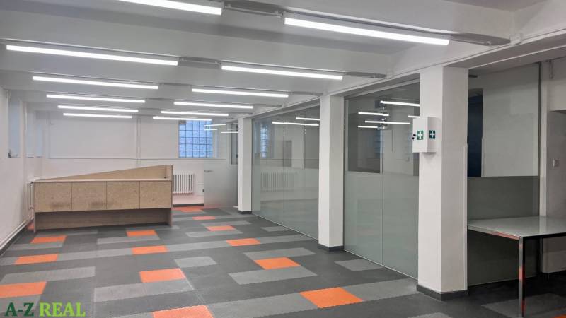 Obchodní prostory se skleněnými stěnami a vzorovanou podlahou s dřevěným dekorem.