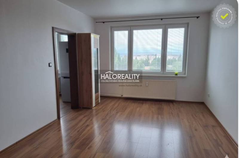 Pokoj s podlahou s dřevěným dekorem a velkými okny v 3pokojovém bytě.