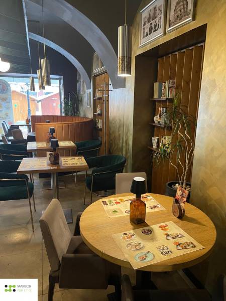 Interiér gastro prostorů s dřevěným dekorem a dekorací na stěnách.