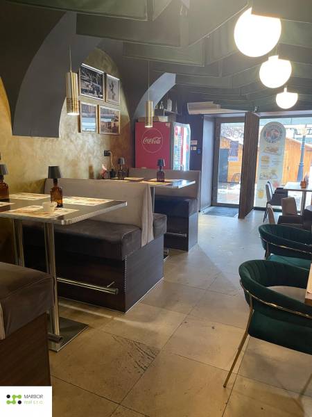 Interiér gastro prostoru s pohodlnými sedadly a dekorativními svítidly.