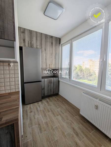 Kuchyně v 2-pokojovém bytě se světlou podlahou s dřevěným dekorem a velkými okny.