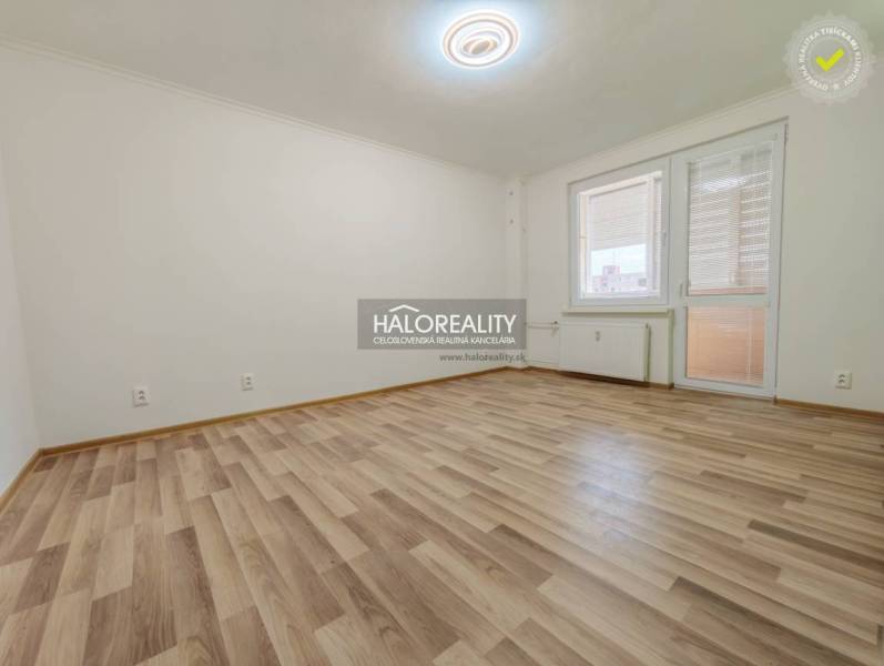 Prostorná místnost v 2-pokojovém bytě s podlahou s dřevěným dekorem.