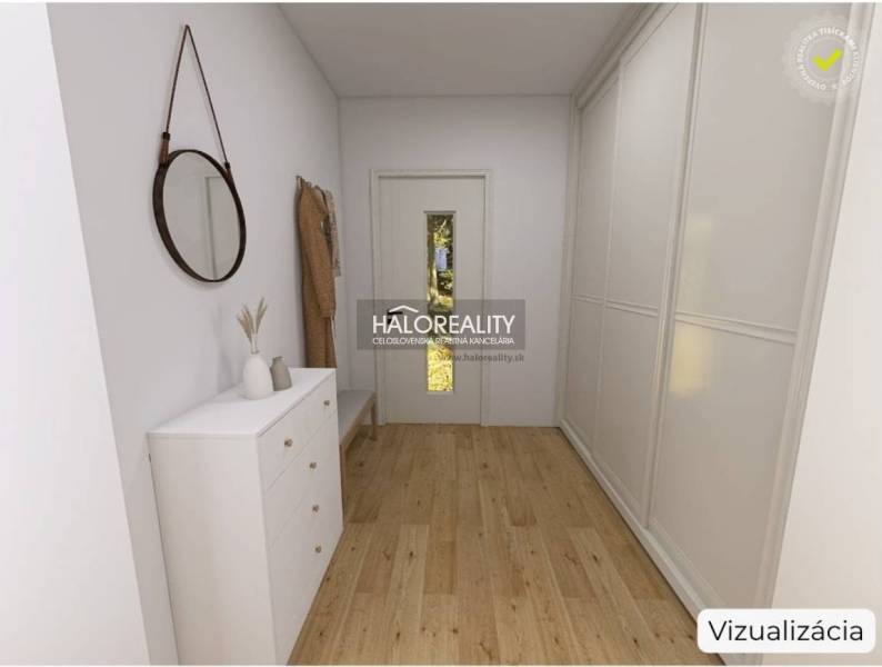 Interiér rodinného domu s podlahou s dřevěným dekorem, bílou komodou a zrcadlem.