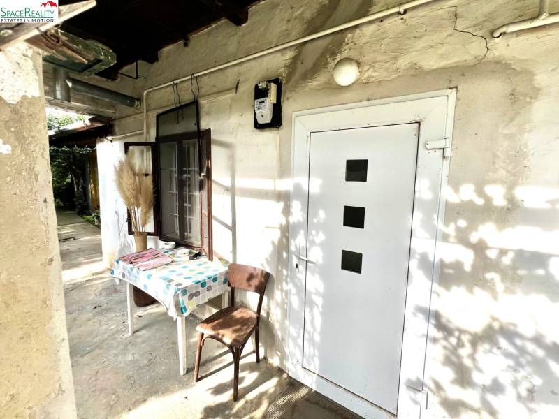 Rodinný dům v Jablonci se stolem a židlí na dvoře.