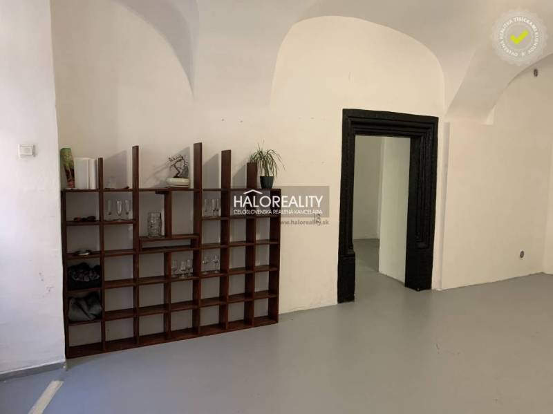 Interiér kanceláře s klenutými stropy a dřevěnou knihovnou.