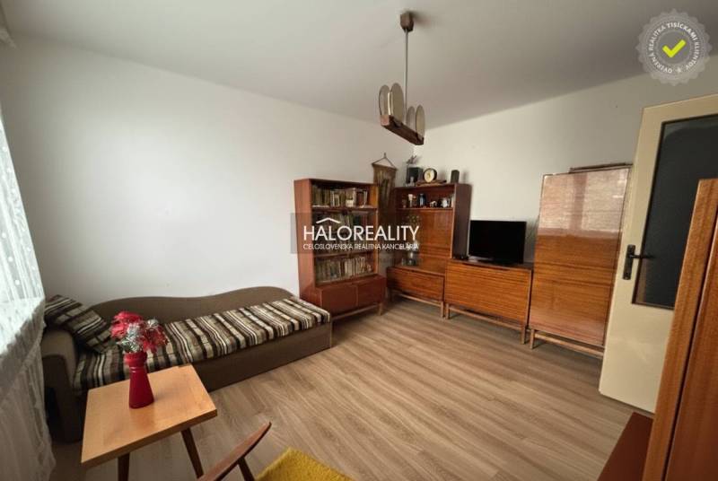 Obývací pokoj v 3-pokojovém bytě s podlahou s dřevěným dekorem, dřevěný nábytek, pohovka.