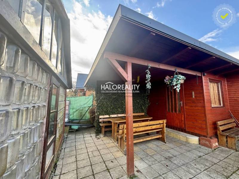 Dřevěný altán se stolem a lavičkami v zahradách Spišské Nové Vsi.