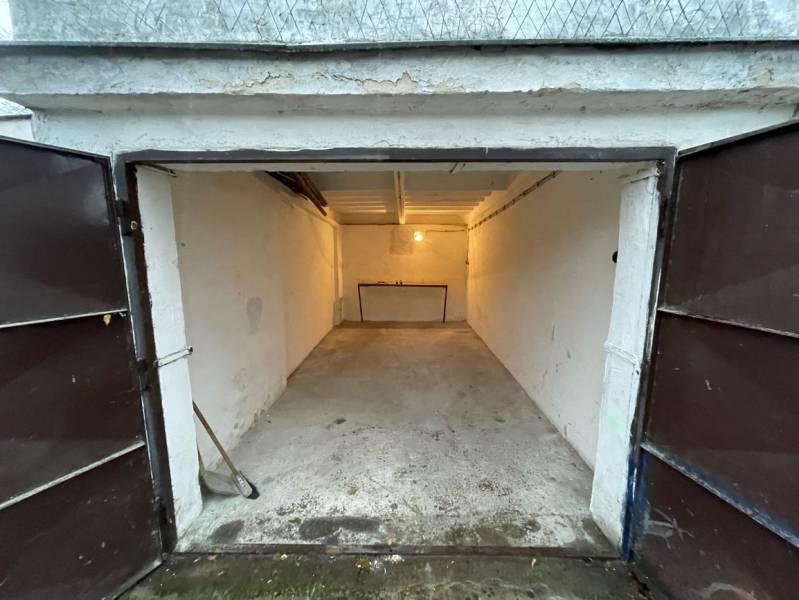 Otevřená garáž na Priekopách v Bratislavě - Ružinov, s betonovou podlahou a čelním stolem.