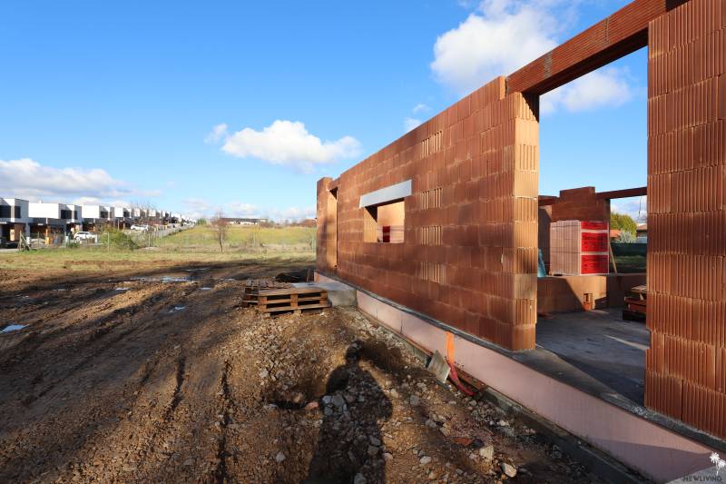 Rozestavěný rodinný dům na Drieňové ulici v Nitře s cihlovou konstrukcí a stavebním materiálem.