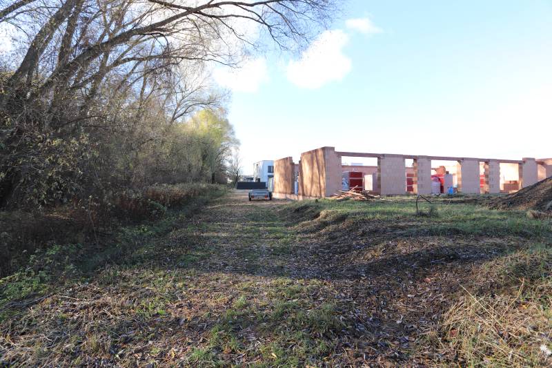 Rozestavěný rodinný dům na Drieňové ulici v Nitře obklopený stromy a přírodou.