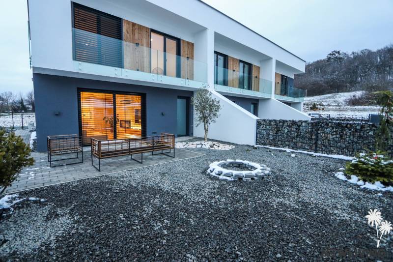 Exteriér rodinného domu na ulici Modrovka, Modrovka, s okruhy z kamene a terasou.