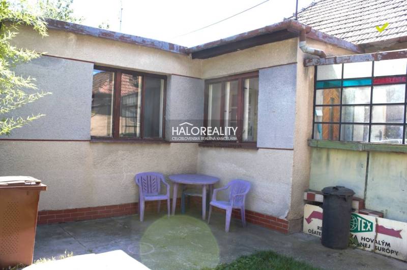 Rodinný dům v Trnavě, venkovní dvůr s plastovým stolem a židlemi, květináč.