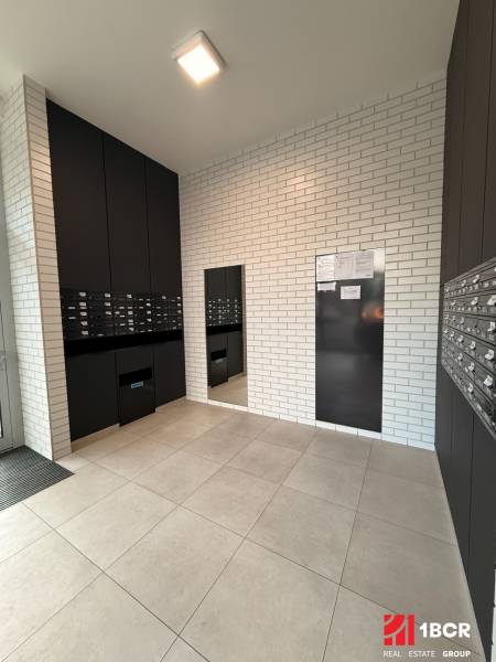 Vstupní hala se skříňkami a cihlovými stěnami v 2pokojovém bytě.