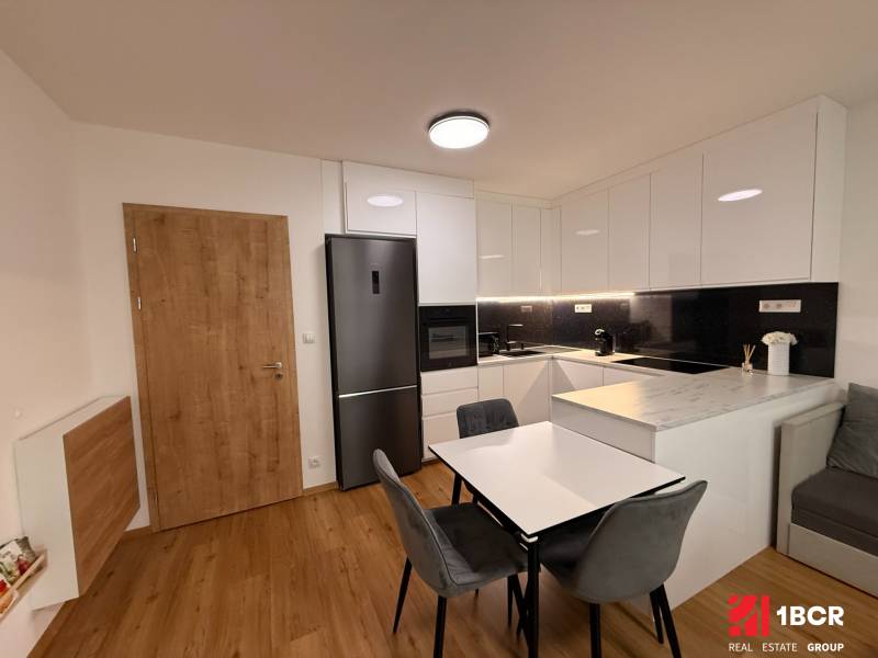 Kuchyně v 2-pokojovém bytě s podlahou s dřevěným dekorem a vestavěnými spotřebiči.