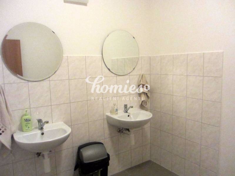 Koupelna se dvěma umyvadly a kulatými zrcadly v kanceláři.