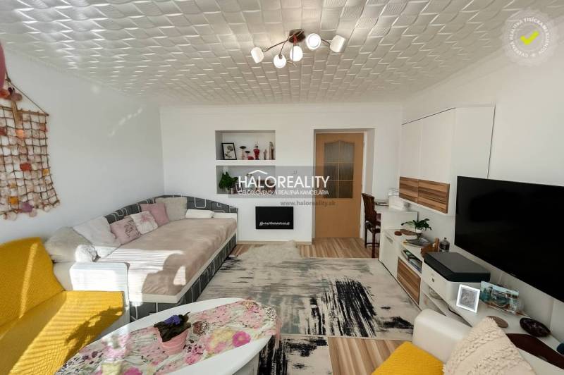 Obývací pokoj s pohodlnou pohovkou v 2pokojovém bytě, podlaha s dřevěným dekorem.