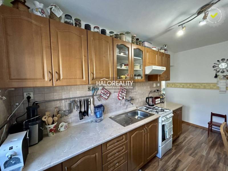 Kuchyně se skříňkami v 2-pokojovém bytě s podlahou s dřevěným dekorem.