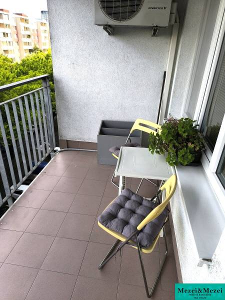 Balkon 2-pokojového bytu v Bratislavě s židlemi a zelení, vhodný k relaxaci.