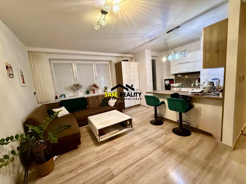 Obývací pokoj a kuchyň v 2pokojovém bytě s podlahou s dřevěným dekorem.