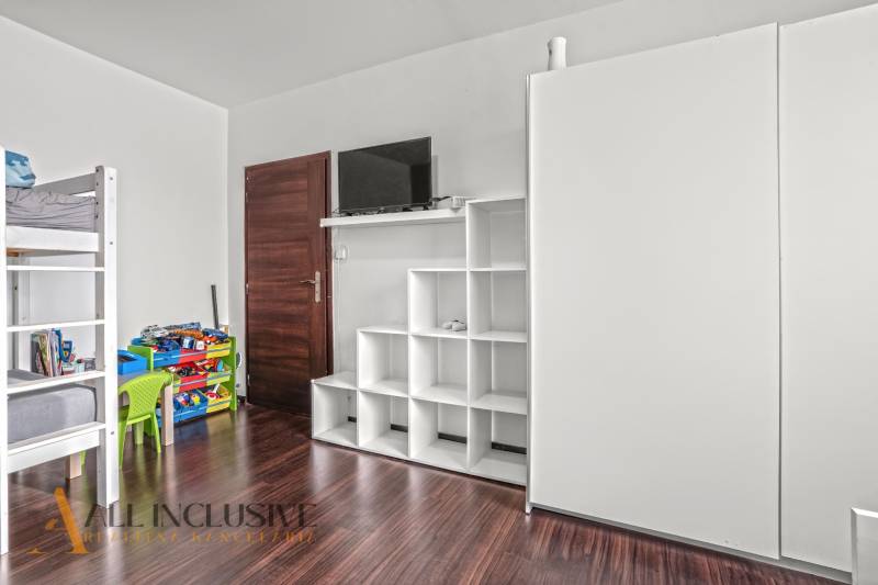 Dětský pokoj s patrovou postelí a úložnými prostory, podlaha s dřevěným dekorem.