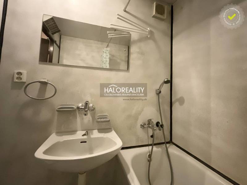 Koupelna ve 3-pokojovém bytě s vanou, zrcadlem a bílým umyvadlem.