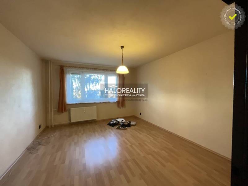 Obývací pokoj ve 3-pokojovém bytě s podlahou s dřevěným dekorem a velkým oknem.