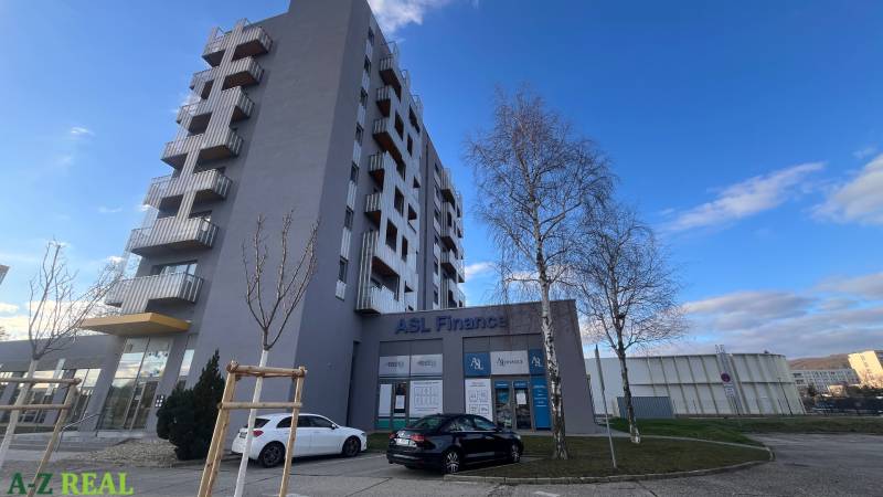 Budova s kancelářemi na Račianské v Bratislavě - Rači a parkovištěm před budovou.