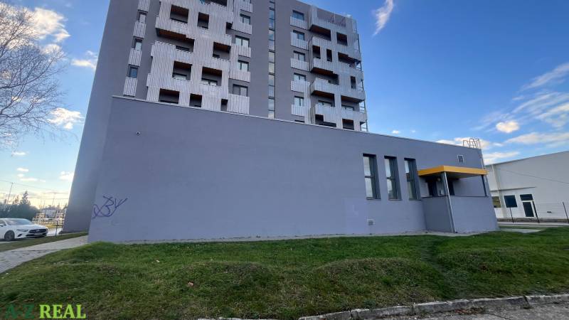 Budova s balkony a šedou fasádou na Račianské ulici v Bratislavě-Rači.