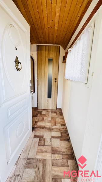 Chata s dřevěným stropem a podlahou s dřevěným dekorem v útulném interiéru.