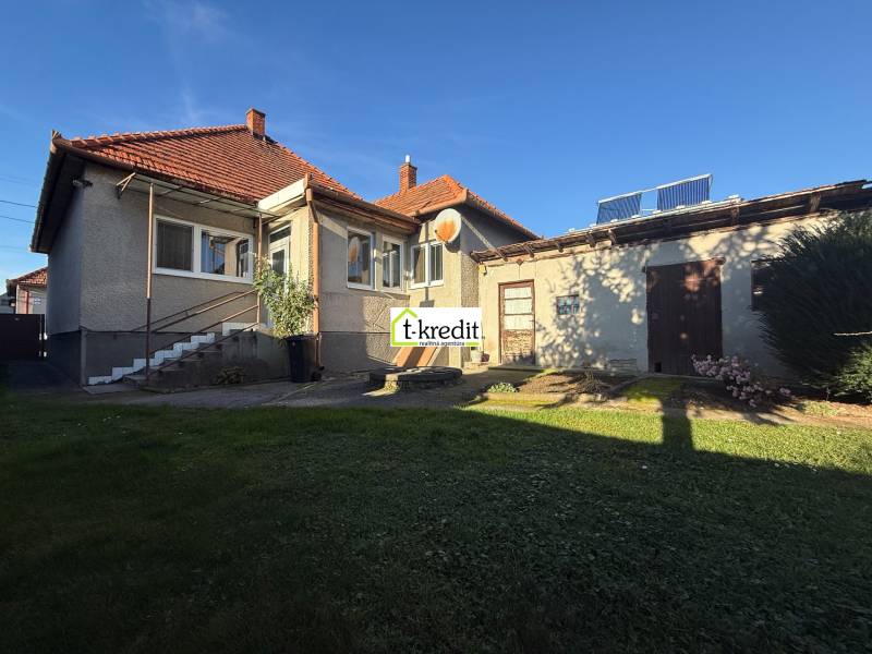 Rodinný dům v Machulincích se zahradou a přístavbou, na modré obloze slunečný den.