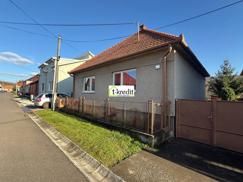 Ulice s rodinným domem v Machulincích, obloha je jasná a slunečná.