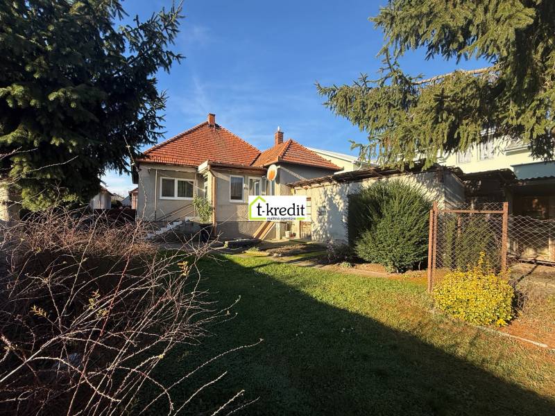 Rodinný dům v Machulincích s červenou taškovou střechou, zahradou a vzrostlými stromy.