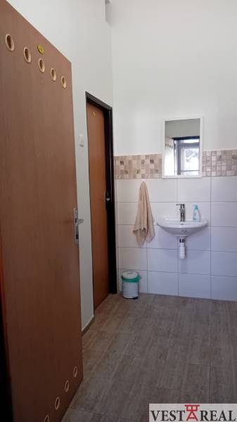 Kanceláře s umyvadlem, zrcadlem a podlahou s dřevěným dekorem.