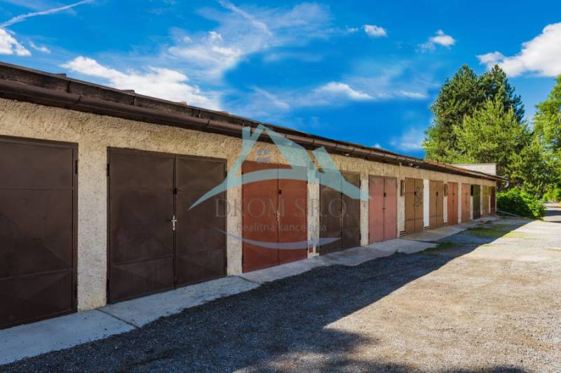 Řada za řadou, na Pálovické cestě, stojí garáže s plechovými dveřmi.