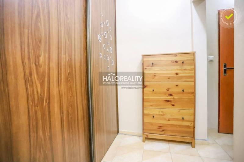 Chodba se skříní a komodou ve 2-pokojovém bytě s dlažbou.