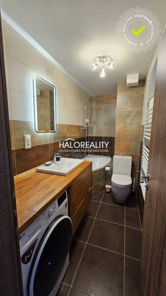 Koupelna v 2-pokojovém bytě se sprchovým koutem a podlahou s dřevěným dekorem.