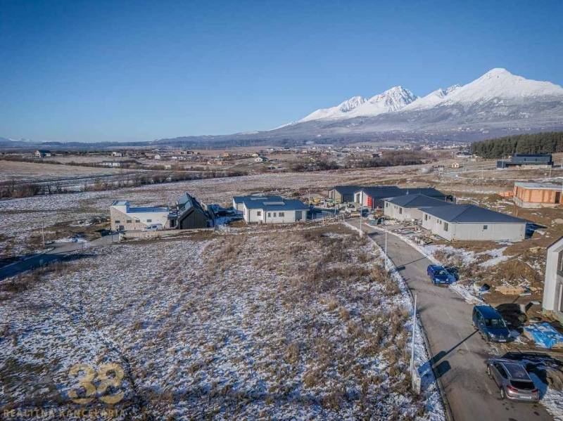 Pozemky na bydlení v Mlynici s rozestavěnými domy a zasněženou krajinou.