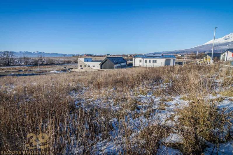 Pozemky k bydlení v Mlynici s panoramatickým výhledem a moderními stavbami v pozadí.