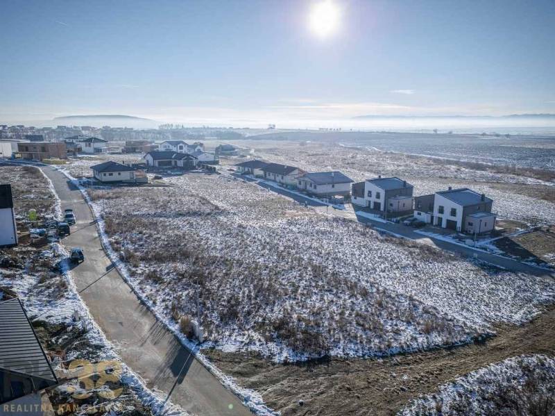 Sněhem pokryté pozemky - bydlení v Mlynici s výhledem na okolní hory.