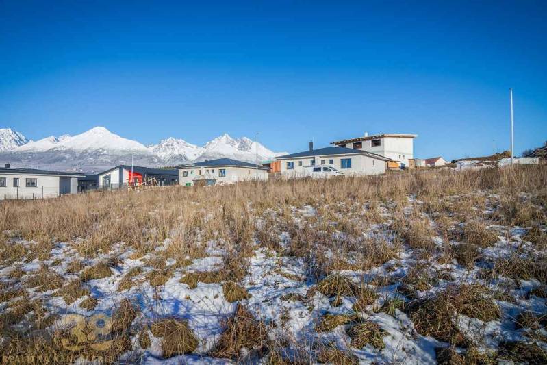 Pozemky k bydlení v Mlynici s panoramatickým výhledem a moderními stavbami v pozadí.