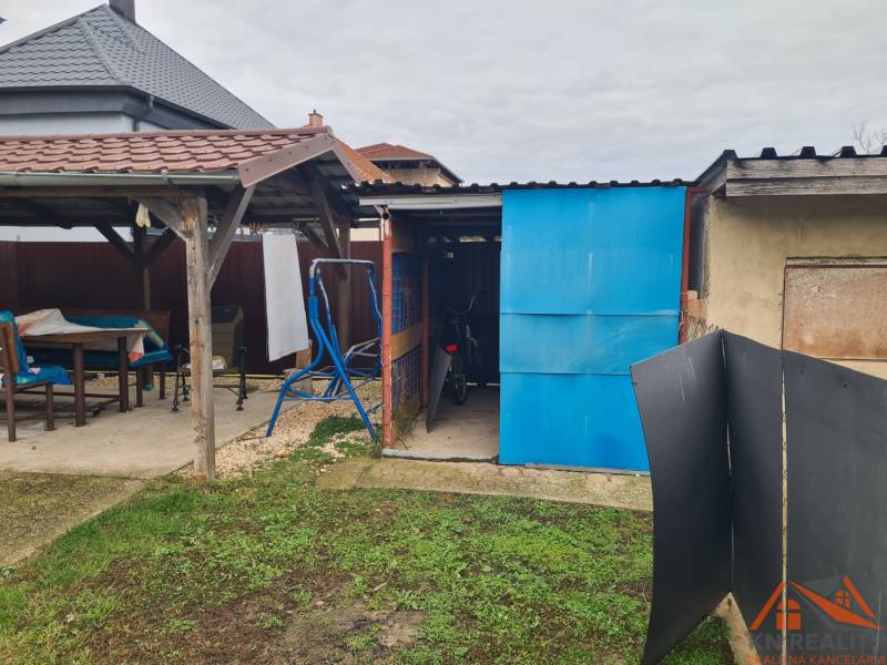 Zahrada rodinného domu v Hurbanově, altán, kůlna, kolo, houpačka, travnatá plocha.