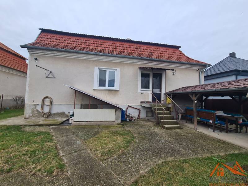 Rodinný dům v Hurbanově s červenou střechou a venkovním posezením na zahradě.