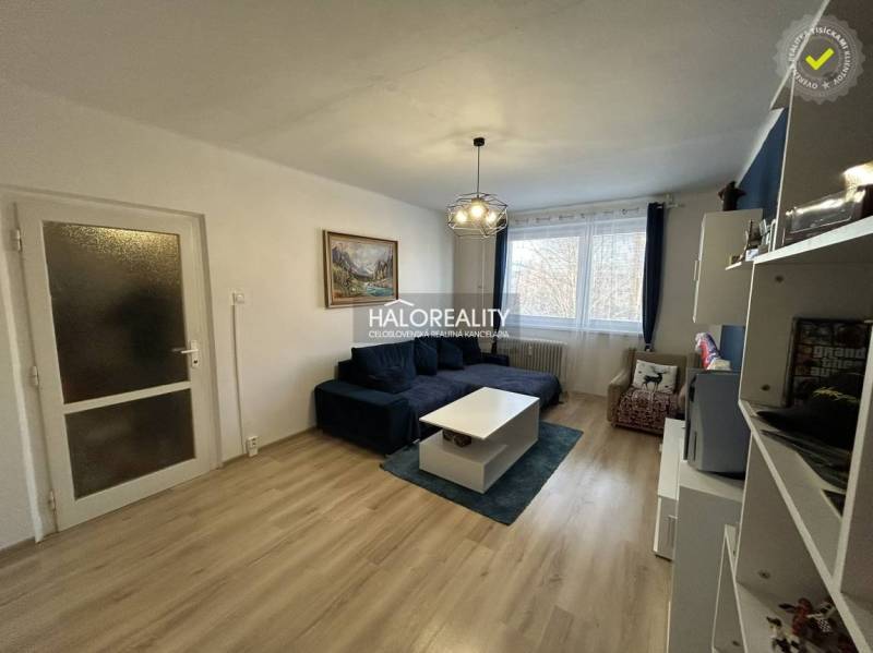 Obývací pokoj v 2-pokojovém bytě s podlahou s dřevěným dekorem a pohodlnou sedačkou.