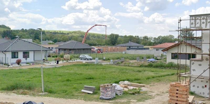 Pozemky - bydlení v Modrovce; vidět rozestavěné domy a stavební materiál.