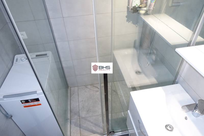 Koupelna se sprchovým koutem a pračkou v 3-pokojovém bytě.