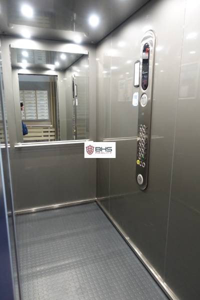 Interiér výtahu s ovládacím panelem a zrcadlem v 3-pokojovém bytě.